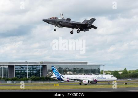 RAF Lockheed Martin F-35B Lightning II Jet Jäger fliegt über einem Airbus A321XLR - Extra Long Range - auf der Farnborough International Airshow 2024, Großbritannien Stockfoto