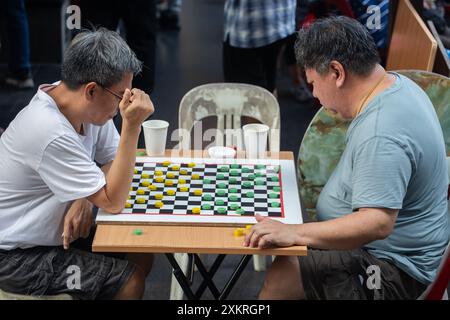 Zwei chinesische Männer mittleren Alters spielen gegeneinander in Chinatown, Singapur. Stockfoto