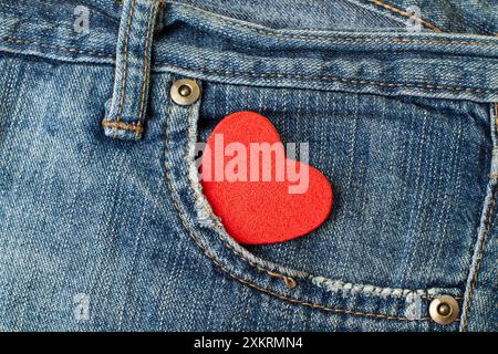 Ein rotes Herz in der Tasche einer blauen Jeanshose aus nächster Nähe Stockfoto