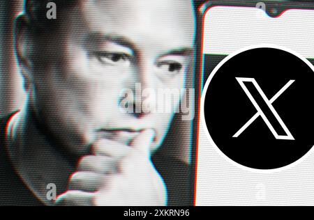 Defokussiertes, glitschiges Porträt von Elon Musk, der auf ein Smartphone mit dem neuen X-Hochtöner-Logo blickt. Stockfoto