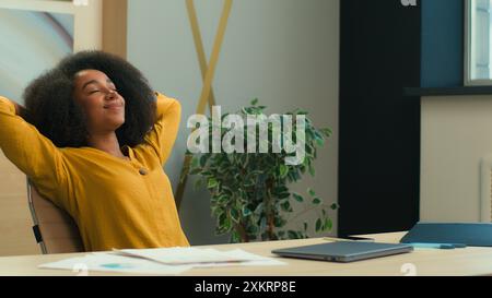 Afroamerikanische Geschäftsfrau Geschäftsfrau Mädchen Büroleiterin mit Laptop im Büro zufrieden entspanntes Stretching am Stuhl Relax Ruhe gesetzt Stockfoto