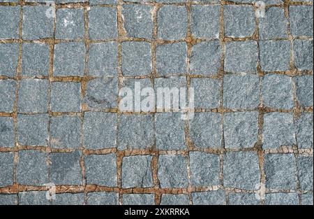 Gerissene Betonwand mit grauer Zementoberfläche. Graue alte Wand mit schäbigem, beschädigtem Putz oder Zement und Backsteinhintergrund eines alten schmutzigen E Stockfoto