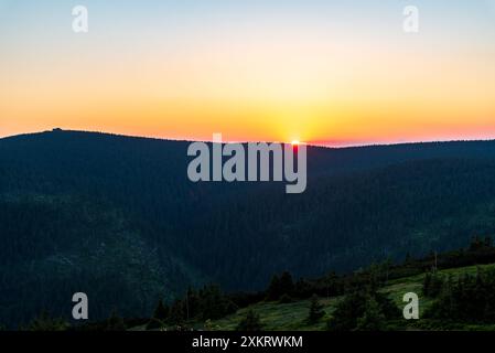 Sommersonnenuntergang mit orangefarbenem Himmel Vozka Hügel vom Cervena hora Hügel in Jeseniky Berge in Tschechien Stockfoto