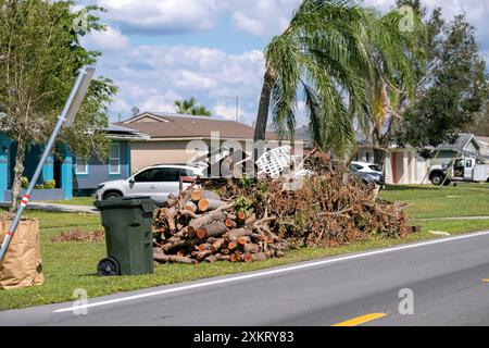 Haufen von Gliedmaßen und Ästen, Trümmer von Hurrikanwinden auf der Straße, die auf die Abholung von einem Bergungswagen in Wohngebieten warten. Konsequenzen der Natur Stockfoto