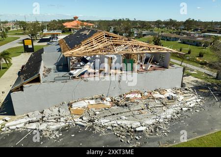 Der Wind zerstörte das Hausdach und die Wände mit fehlenden Asphaltschindeln nach dem Hurrikan Ian in Florida. Abriss von Gebäuden nach Naturkatastrophen Stockfoto