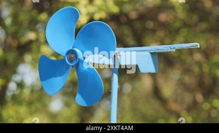 Eine blaue Flügelfahne dreht sich im Sommer im Wind. Stockfoto