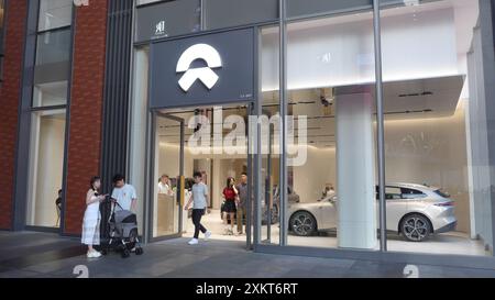 Kunden verlassen den chinesischen multinationalen Automobilhersteller, den NIO Store und das Logo in Shenzhen, China Stockfoto