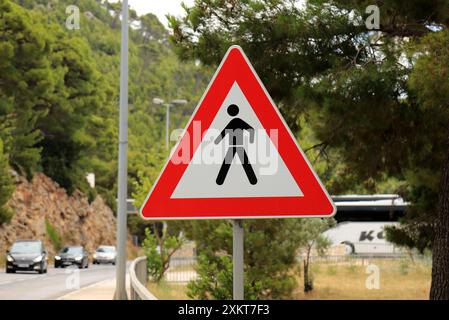 Straßenschild Fußgängerüberquerung auf einer Bergstraße in Kroatien. Dreieckiges Warnschild für Fußgänger, um die Straße sicher zu überqueren. Geben Sie Fußgänger Frei Stockfoto