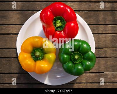 Ein Blick von oben auf frische leckere Paprika auf der Platte auf der Holzoberfläche Stockfoto