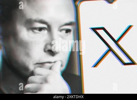 Elon Musk schaut sich ein Smartphone mit dem neuen Twitter-Logo an. Speicherplatz auf Ihrem Smartphone kopieren. Stockfoto