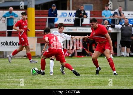 Briton Ferry, Wales. 23. Juli 2024. Aidan Higgins aus Swansea City kämpft am 23. Juli 2024 mit zwei Spielern der Briton Ferry Llansawel gegen Swansea City im Freundschaftsspiel zwischen Briton Ferry Llansawel und Swansea City unter 18 Jahren auf der Old Road in Briton Ferry, Wales, Großbritannien. Quelle: Duncan Thomas/Majestic Media. Stockfoto