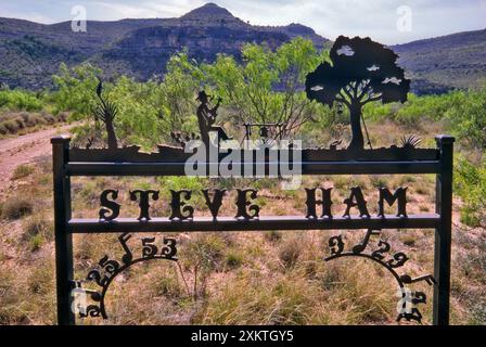 Schmiedeeisernes Schild zum Gedenken an eine Person am Ranch-Eingang in der Dämmerung in der Nähe von Pandale, Pecos River Valley, Stockton Plateau im Val Verde County, Texas, USA Stockfoto