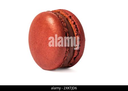 Ein einzelner, roter Macaron mit Erdbeerfüllung wird in einer Nahaufnahme dargestellt. Der Macaron ist auf einem weißen Hintergrund isoliert, was seine vibra hervorhebt Stockfoto