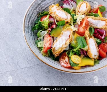 Salat mit Panko-Garnelen, Avocado und Mango auf grauem Hintergrund für das Restaurantmenü, Stockfoto