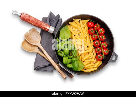 Eine lebendige Darstellung der italienischen Flagge mit Pasta, Basilikum und Tomaten, wunderschön in einer Pfanne präsentiert. Flache Lagen. Isoliert auf weiß Stockfoto