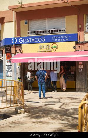 Viladecasn, SPANIEN - 24. JULI 2024: Foto einer funktionierenden Eisdiele in städtischer Umgebung. Die rosa Markise und die Anwesenheit von Kunden suggerieren Stockfoto