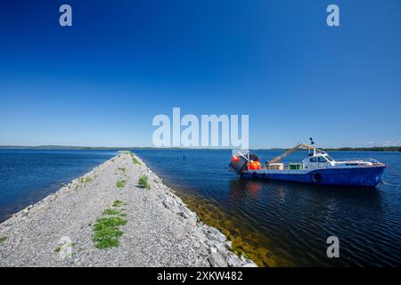 Kleiner finnischer Binnensee-Trawler, der hinter dem Seegang am See Pohjois-Konnevesi in Finnland ankert Stockfoto