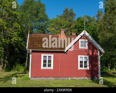 Schwedisches rotes Cottage. Traditionelles Holzhaus mit weißen Ecken Stockfoto