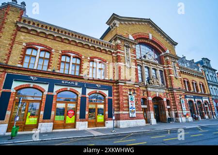 BUDAPEST, UNGARN - 21. FEBRUAR 2022: Die Fassade einer historischen Markthalle mit großen Supermarktschildern, am 21. Februar in Budapest Stockfoto