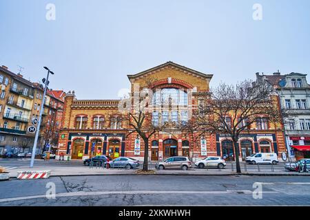 BUDAPEST, UNGARN - 21. FEBRUAR 2022: Die Fassade einer historischen Markthalle mit großen Supermarktschildern im Herzen des Buda-Viertels Stockfoto