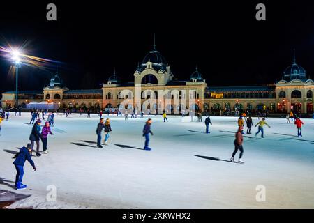 BUDAPEST, UNGARN - 21. FEBRUAR 2022: Aktivität auf der belebten City Park Eislaufbahn in der Nacht, Menschen auf einer großen Eislaufbahn, am 21. Februar in Budapest Stockfoto