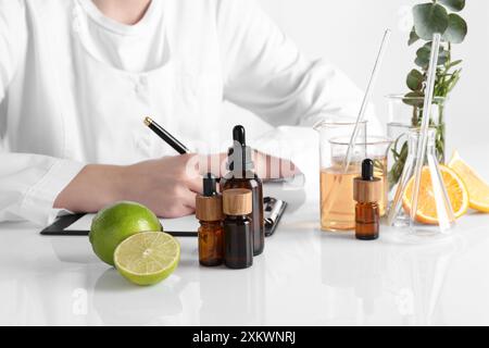 Aromatherapeutikum. Wissenschaftler, der ätherische Öle am weißen Tisch im Labor entwickelt, Nahaufnahme Stockfoto
