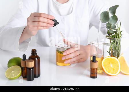 Aromatherapeutikum. Wissenschaftler, der ätherische Öle am weißen Tisch im Labor entwickelt, Nahaufnahme Stockfoto