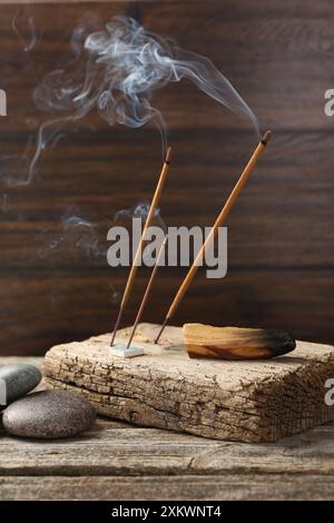 Aromatischer Weihrauch klebt schwelend auf Holztisch Stockfoto