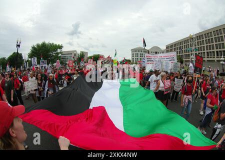 Washington, DC, USA. Juni 2024. Während der Rede des israelischen Premierministers Benjamin Netanjahu vor einer gemeinsamen Kongresssitzung tragen die Demonstranten eine große palästinensische Flagge auf der Straße in der Nähe des Kapitols. Quelle: Philip Yabut/Alamy Live News Stockfoto