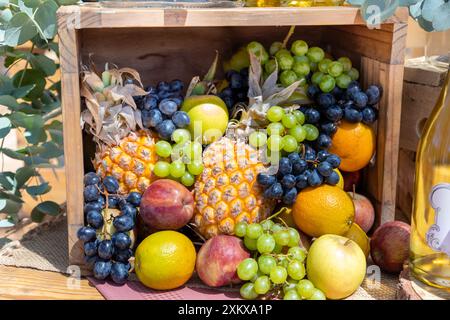 Auswahl an verschiedenen Sommerfrüchten in einem quadratischen Holzkorb. Stockfoto