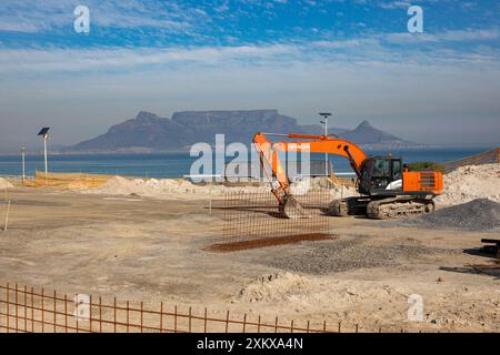 Strandbaustelle, die flach ist und für den Baubeginn in Blouberg Strand Kapstadt bereit ist. Hitachi Bagger vor Ort. Stockfoto