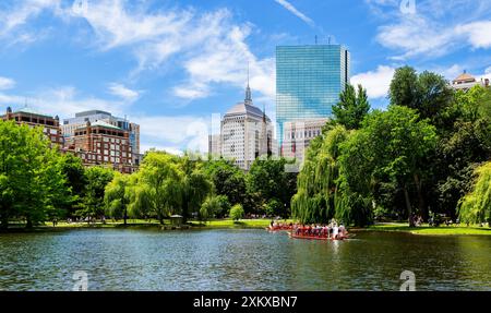 Boston, Massachusetts, USA – 18. Juni 2022: Boston Public Garden Pond mit einem Schwanenboot und Back Bay Gebäuden im Hintergrund. Stockfoto