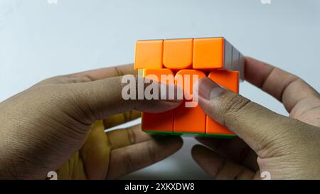 Farbenfrohe, abgeschlossene Lösung des 3x3-Würfels wird isoliert auf weißem Hintergrund in der Hand gehalten Stockfoto