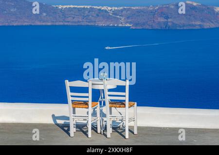 Zwei Stühle und ein kleiner Tisch mit einer wunderbaren Aussicht auf Santorin, Griechenland Stockfoto