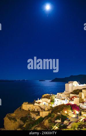 Atemberaubende Aussicht auf die Insel Santorin bei Nacht bei aufsteigendem Vollmond. Santorin, Griechenland Stockfoto