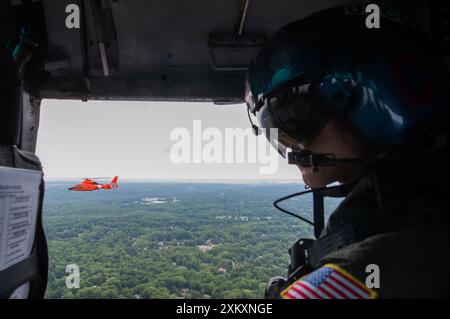Der Petty Officer der US-Küstenwache 3rd Class Even Arko, ein Crewmitglied auf der Coast Guard Air Station Atlantic City, führt am 18. Juli 2024 eine Formationsübung in einem Dolphin-Helikopter MH-65 durch, während er der Coast Guard Air Station Washington in Washington D.C. zugeteilt wurde. Arko diente während der Übung als Wartungstechniker für die Luftfahrt mit einer anderen MH-65 Dolphin Crew. (Foto der US-Küstenwache von Petty Officer 3rd Class Christopher Bokum) Stockfoto