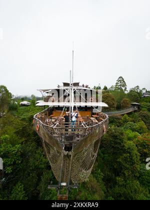 Touristen posieren auf Deck des großen Holzschiffes-Restaurants im Lembang Forest Stockfoto