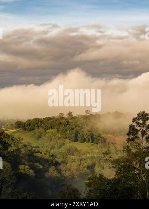 Einige Nebel bedeckt die Berge und Farmen bei Sonnenaufgang, in den östlichen Andengebirgen in Zentral-Kolumbien. Stockfoto