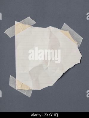 Gerissenes Regelpapier mit Klebeband, Papierfetzen auf Klebeband, grauer Hintergrund. Stockfoto