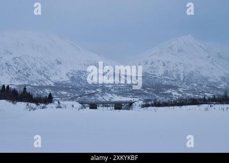 Brücke auf dem Richardson Highway mit Bergen im Hintergrund an einem kalten Wintertag in der Nähe der Castner Cave in Alaska. Stockfoto