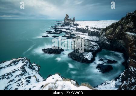 Die wunderschönen Klippen Londrangar und Pofubjarg in Island, Basaltfelsen, Wellen des Atlantiks während des Wintersturms, dunkle Tage Stockfoto