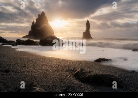 Schwarzer Sandstrand in Island, in der Nähe der Stadt Vik, auch Reynisfjara genannt, am Atlantischen Ozean, Wellen, farbenfroher Sonnenaufgang, Touristenziel Stockfoto