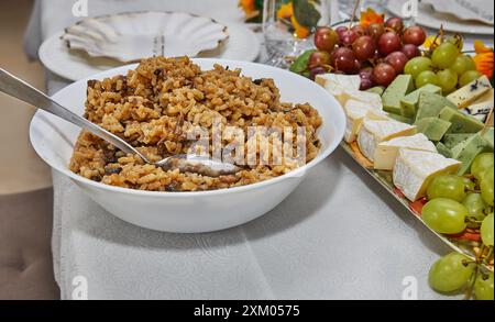 Nahaufnahme eines Löffels mit köstlichem Pilzrisotto in der Küche, das die cremige Textur und die herzhaften Zutaten hervorhebt. Stockfoto