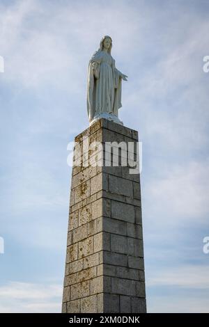 Die Statue der Jungfrau Maria mit Blick auf den Gold Beach in Arromanches Stockfoto