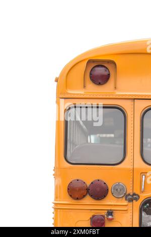 Von hinten ist ein hellgelber Schulbus vor weißem Hintergrund zu sehen Stockfoto