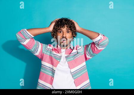 Foto von schockiertem beeindrucktem Mann tragen trendige gestreifte Kleidung isoliert auf cyanfarbenem Hintergrund Stockfoto
