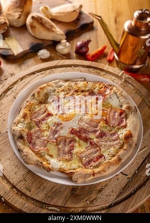 Carbonara Pizza mit Speck auf Holzbrett Stockfoto