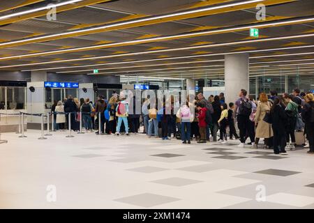 Ankommende Passagiere, hauptsächlich Touristen im Urlaub, an der Ankunftschlange, um mit den Beamten an der Passkontrolle zu sprechen. Flughafen Split, Kroatien. (138) Stockfoto