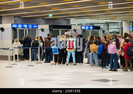 Ankommende Passagiere, hauptsächlich Touristen im Urlaub, an der Ankunftschlange, um mit den Beamten an der Passkontrolle zu sprechen. Flughafen Split, Kroatien. (138) Stockfoto