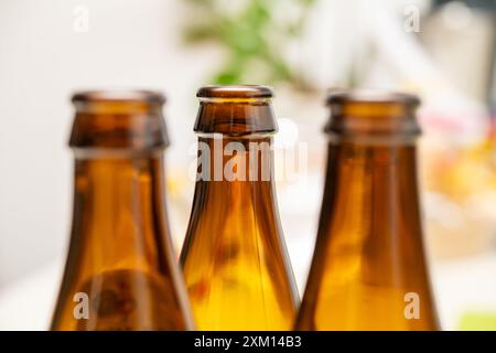 Drei wunderschön gefertigte Braunglasflaschen stehen eng und weisen ihre einzigartigen Formen und Strukturen auf, ideal für die Verwendung im Getränkemarken, Packa Stockfoto